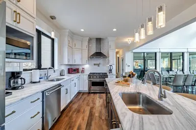 a large kitchen with white cabinets and a sink at The Perfect Pocono Escape in Pocono Farms East
