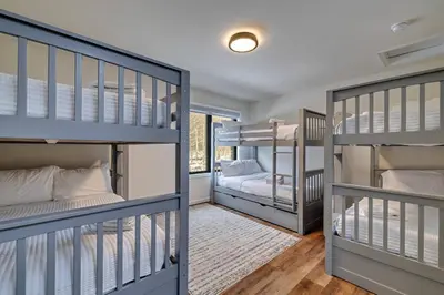 a room with three bunk beds and a hallway at The Perfect Pocono Escape in Pocono Farms East
