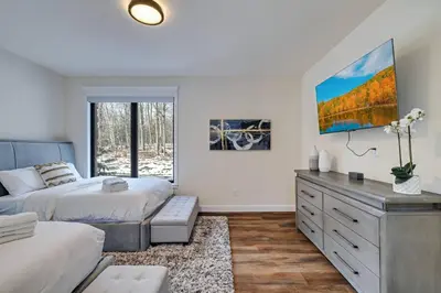 a bedroom with a bed and a dresser and a window at The Perfect Pocono Escape in Pocono Farms East