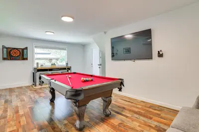 a red pool table in a room with a tv at Hot Tub and Game Room Wooded Poconos Retreat in Tobyhanna