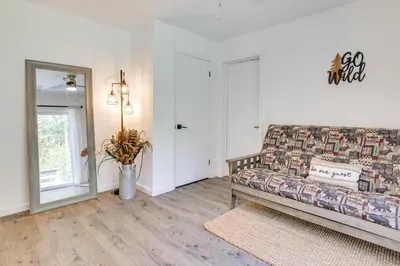 a living room with a couch and a mirror at Hot Tub and Game Room Wooded Poconos Retreat in Tobyhanna