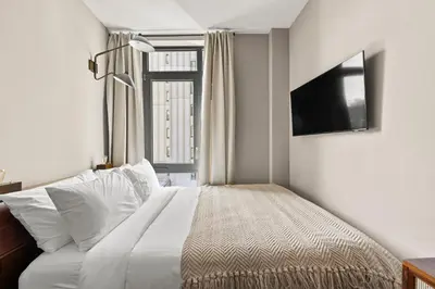 a bedroom with a bed and a tv and a window at Freeman 602 by Rove Travel - Condo with Shared Amenities in New York