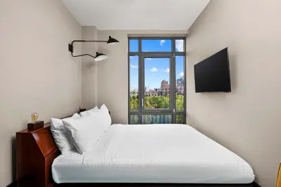 a bedroom with a white bed and a window at Freeman 603 by Rove Travel - Studio with Shared Amenities in New York