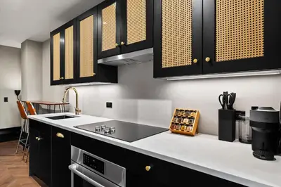 a kitchen with black cabinets and a sink at Freeman 603 by Rove Travel - Studio with Shared Amenities in New York