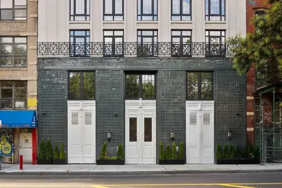 a brick building with white doors on a street at Freeman II by Rove 1BR Condo with Shared Amenities in New York
