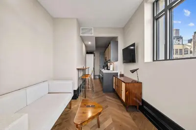 a living room with a white couch and a tv at Freeman II by Rove 1BR Condo with Shared Amenities in New York