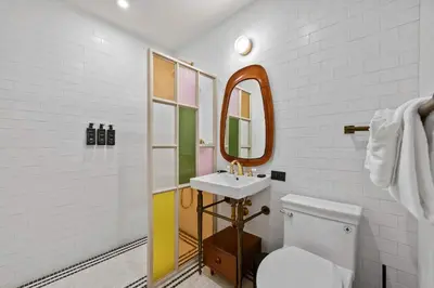 a bathroom with a sink and a toilet and a mirror at Freeman II by Rove 1BR Condo with Shared Amenities in New York