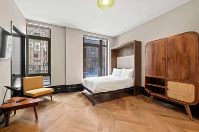 a bedroom with a bed and a chair at Freeman 201 by Rove Travel - 2BR Condo with Shared Amenities in New York