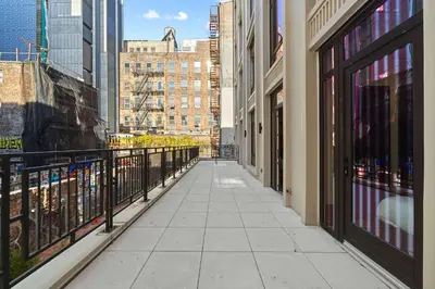 an empty walkway in a city with tall buildings at Freeman 201 by Rove Travel - 2BR Condo with Shared Amenities in New York