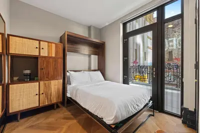 a bedroom with a bed and a large window at Freeman 201 by Rove Travel - 2BR Condo with Shared Amenities in New York