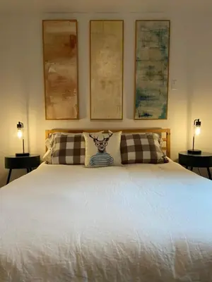 a bedroom with a large white bed with two lamps at Fireplace Catskill Views Overlook Lake Cabin in Parksville