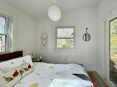 a white bedroom with a bed and a window at Fireplace Catskill Views Overlook Lake Cabin in Parksville