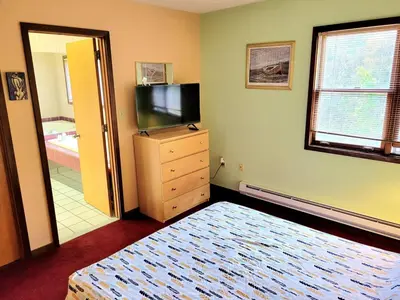 a bedroom with a bed and a flat screen tv at Shawnee Ski Mountain View Jacuzzi Townhouse in East Stroudsburg