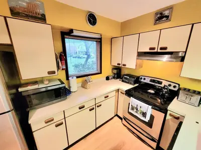 a kitchen with white cabinets and a stove and a window at Shawnee Ski Mountain View Jacuzzi Townhouse in East Stroudsburg