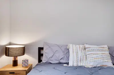 a bedroom with a bed with a lamp and pillows at Winter retreat, hot tub, game room, indoor pool, in Long Pond