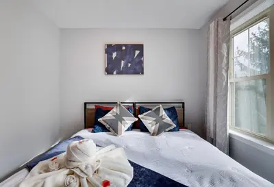 a bedroom with a bed with towels and a window at Mountain Chalet Ski, Hike, & Explore in Tannersville