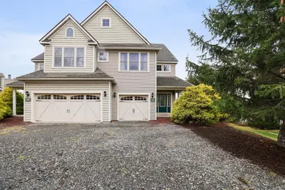 a house with two garage doors on a driveway at Mountain Chalet Ski, Hike, & Explore in Tannersville