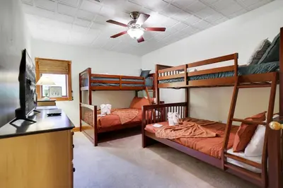 a bedroom with two bunk beds and a ceiling fan at Harmony Haven Large Deck Hot Tub Ski in Split Rock