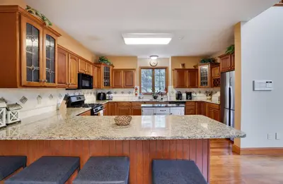 a large kitchen with wooden cabinets and a large island at Harmony Haven Large Deck Hot Tub Ski in Split Rock