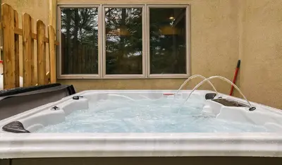 a bath tub filled with water next to a window at Harmony Haven Large Deck Hot Tub Ski in Split Rock