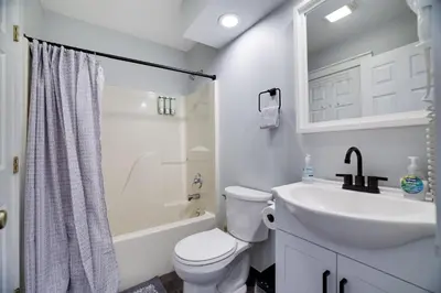 a white bathroom with a toilet and a sink at Spruce Ridge Lodge Ski, Hike & Relax in Tannersville