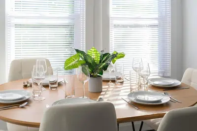a dining room table with glasses and a plant on it at 20 min to NYC, Newly Renovated, Private Driveway in Little Ferry