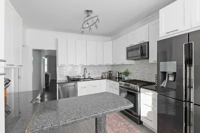 a kitchen with white cabinets and a granite counter top at 20 min to NYC, Newly Renovated, Private Driveway in Little Ferry