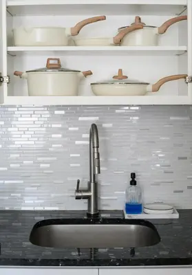 a kitchen counter with a sink and shelves with dishes at 20 min to NYC, Newly Renovated, Private Driveway in Little Ferry