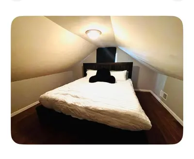 a bed with a black pillow on it in a room at Jersey Oasis in Hazelton
