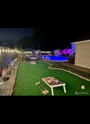 a backyard with a table and baseball equipment on the grass at Jersey Oasis in Hazelton