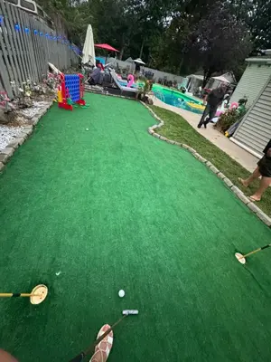 a green playing field with golf clubs and balls on it at Jersey Oasis in Hazelton