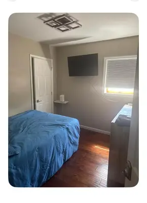 a bedroom with a blue bed and a window at Jersey Oasis in Hazelton