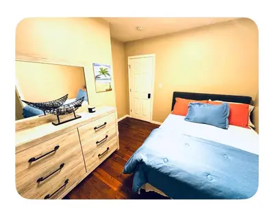 a bedroom with a bed and a dresser with a mirror at Jersey Oasis in Hazelton