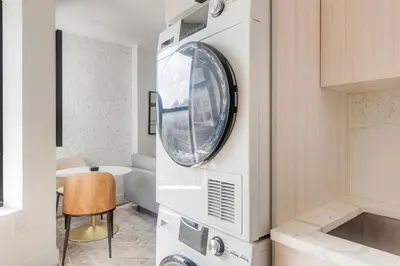 a laundry room with a washer and dryer at Blueground Alphabet City view nr Tompkins Square Park NYC-1978 in New York
