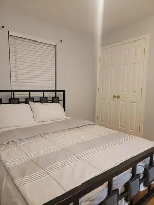 a large bed in a bedroom with a door at Urban Nest in Newark