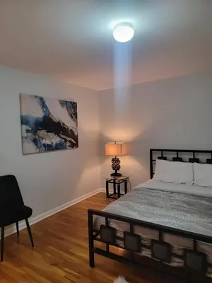 a bedroom with a bed and a lamp and a painting at Urban Nest in Newark