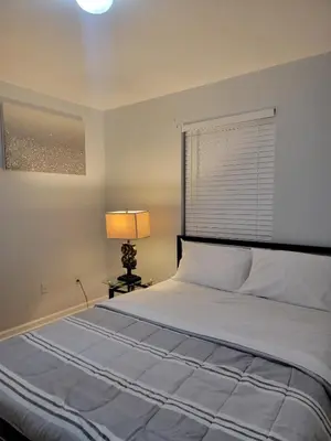 a bedroom with a large bed and a lamp at Urban Nest in Newark