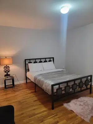 a bedroom with a large bed and a lamp at Urban Nest in Newark