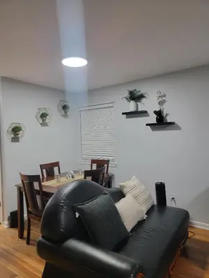 a black leather couch in a living room with a table at Urban Nest in Newark