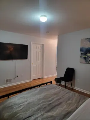a bedroom with a bed and a television on the wall at Urban Nest in Newark