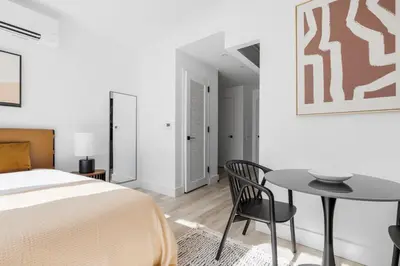 a bedroom with a bed and a table and chair at Blueground Alphabet City rooftop nr Tompkins Square Park NYC-2081 in New York