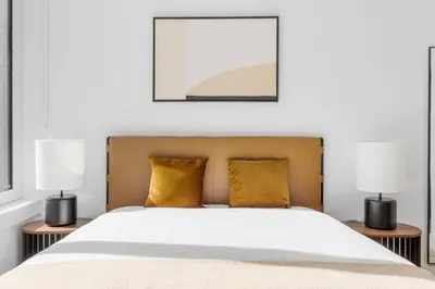 a bedroom with a large bed with two lamps at Blueground Alphabet City rooftop nr Tompkins Square Park NYC-2081 in New York