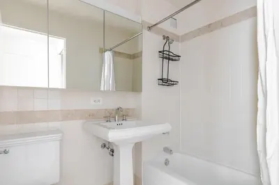 a white bathroom with a sink and a mirror at Blueground Upper West Side fitness nr Central Park NYC-1994 in New York