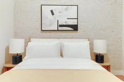 a bedroom with a white bed with two lamps at Blueground Hells Kitchen terrace nr Times Square NYC-2063 in New York