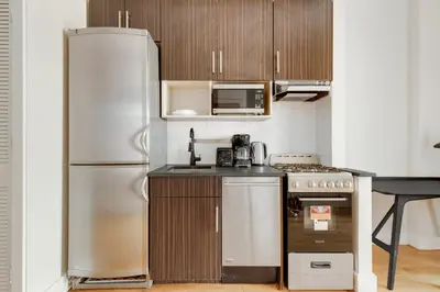 a kitchen with a refrigerator and a stove at Blueground Hells Kitchen terrace nr Times Square NYC-2063 in New York