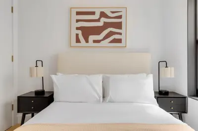 a bedroom with a white bed with two nightstands and two lamps at Blueground Brooklyn Heights view nr Brooklyn Bridge NYC-1987 in Brooklyn