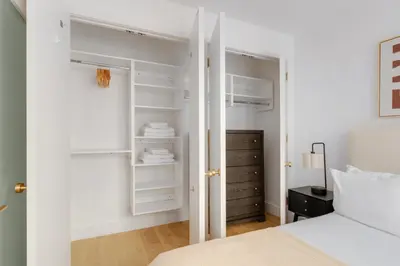 a bedroom with a closet with white shelves at Blueground Brooklyn Heights view nr Brooklyn Bridge NYC-1987 in Brooklyn