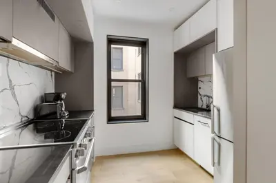 a kitchen with white appliances and a window at Blueground Brooklyn Heights view nr Brooklyn Bridge NYC-1987 in Brooklyn