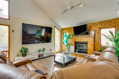 a living room with two leather couches and a fireplace at Luxury Home with Game Room, 4 Mi to Bushkill Falls! in Saw Creek