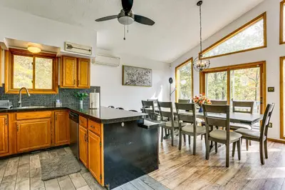 a kitchen and dining room with a table and chairs at Luxury Home with Game Room, 4 Mi to Bushkill Falls! in Saw Creek